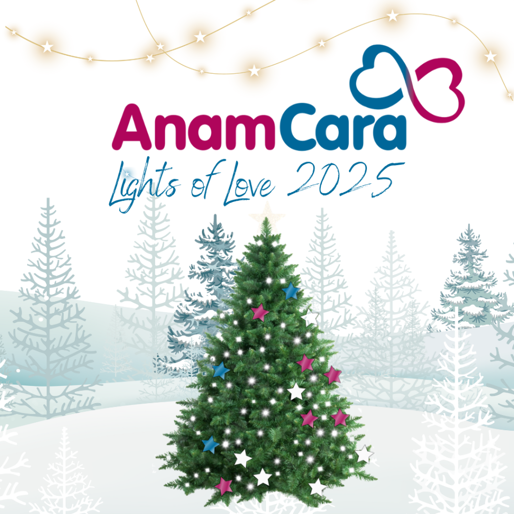 A snowy field with a partially decorated Christmas tree with Anam Cara Lights of Love 2025 written above it