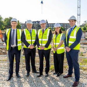 Five professionals standing on abuilding site smiling
