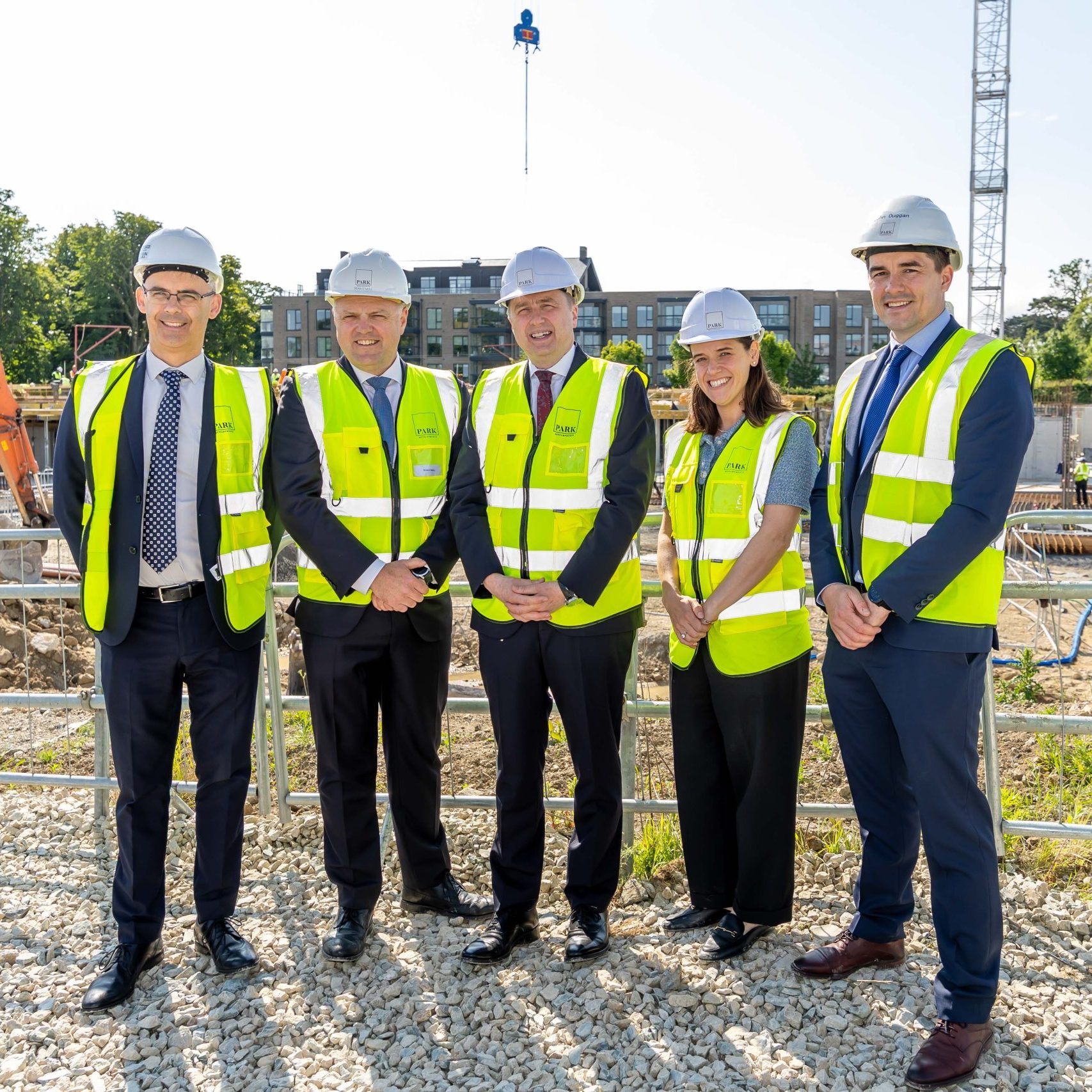 Five professionals standing on abuilding site smiling